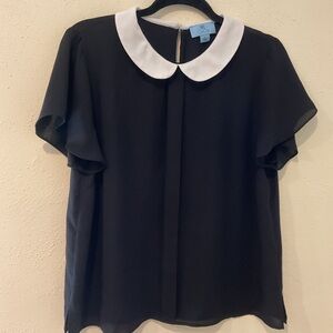 Peter Pan collar black blouse with white collar.